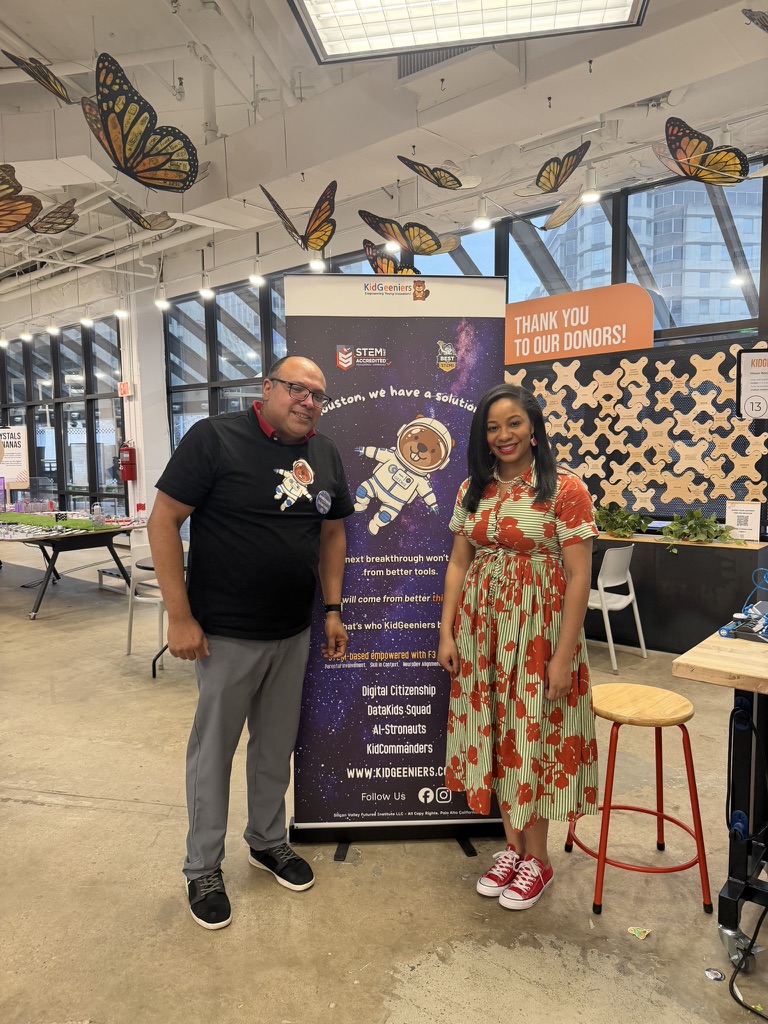 KidGeeniers team at an event booth next to the program banner